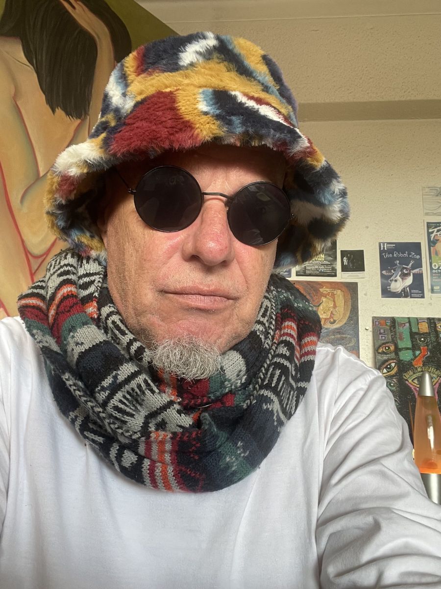 James Kibby in a colourful bucket hat and round sunglasses